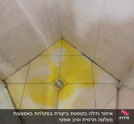 רצפת מקלחת עם כתם צהוב סביב הניקוז